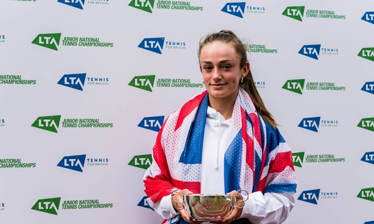 Isabelle Lacy hiding the 18U Junior National Championships trophy