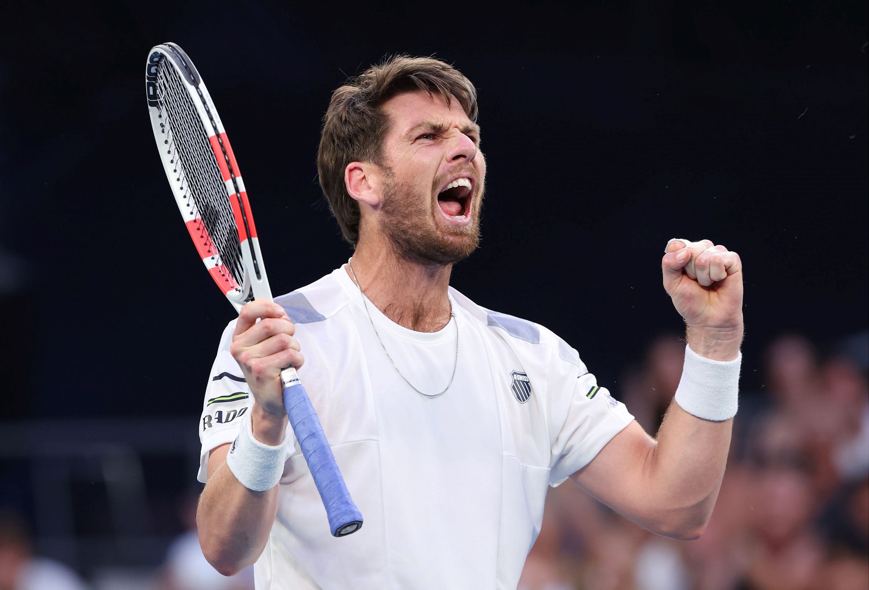 Cam Norrie holding his racket in one hand and clenching his fist in celebration after winning his third round match at the Australian Open