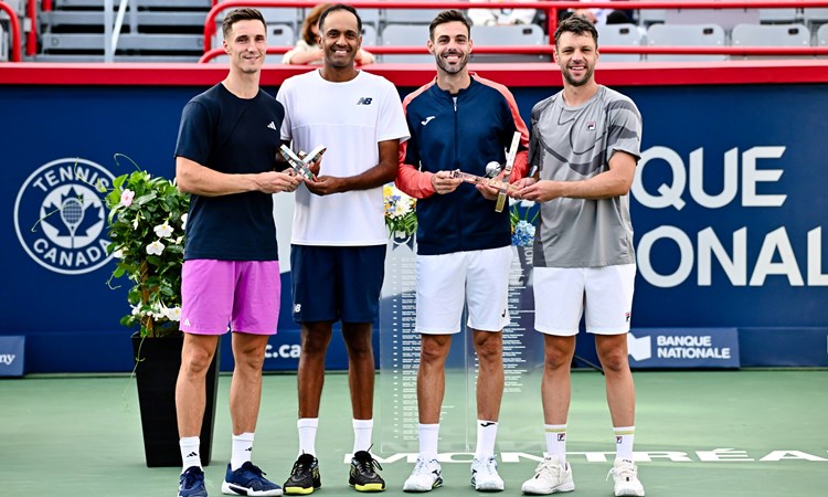 Joe Salisbury and Rajeev Ram holding the National Bank Open runners-up trophies next to champions Marcel Granollers and Horacio Zeballos