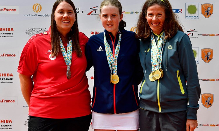 Anna Mcbride wearing her medal posing with two other players